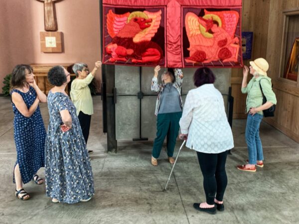 The daughters of Margaret Hays, along with Joann Bailey, Sherry Garman, and Sandy Piscetello inspect the condition of the banner, July 2021.